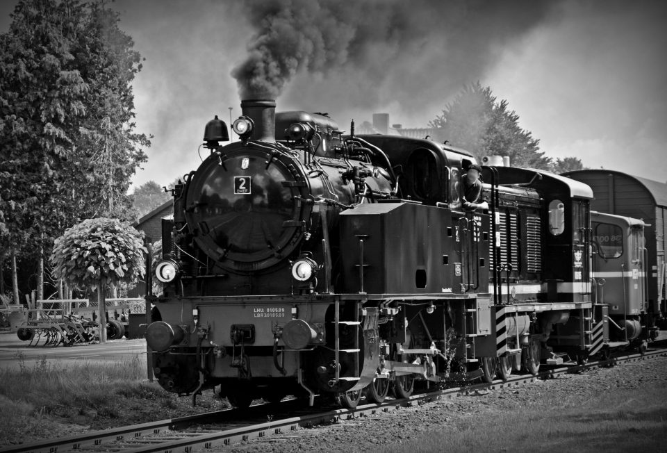 Black and white train with steam coming from the engine.