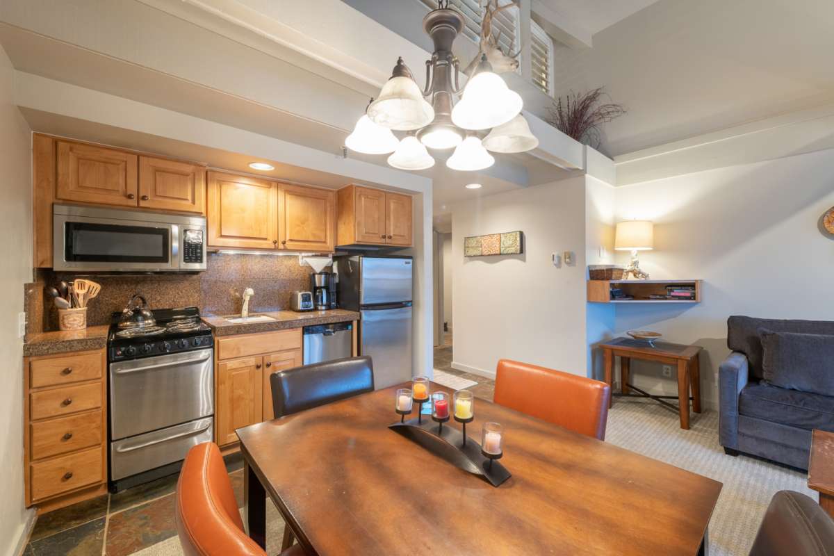 Kitchen with stainless steel appliances, kitchen table in the foreground. 