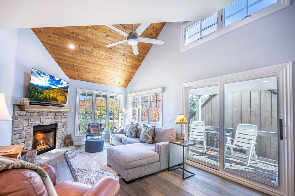 Image shows Park City ski home living room with hardwood flooring, vaulted ceilings, mounted TV